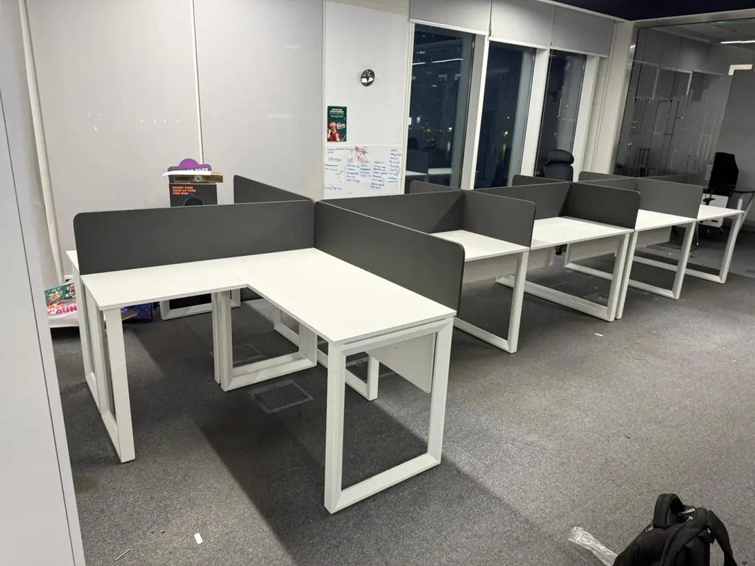 White L-shaped workstations with grey screens