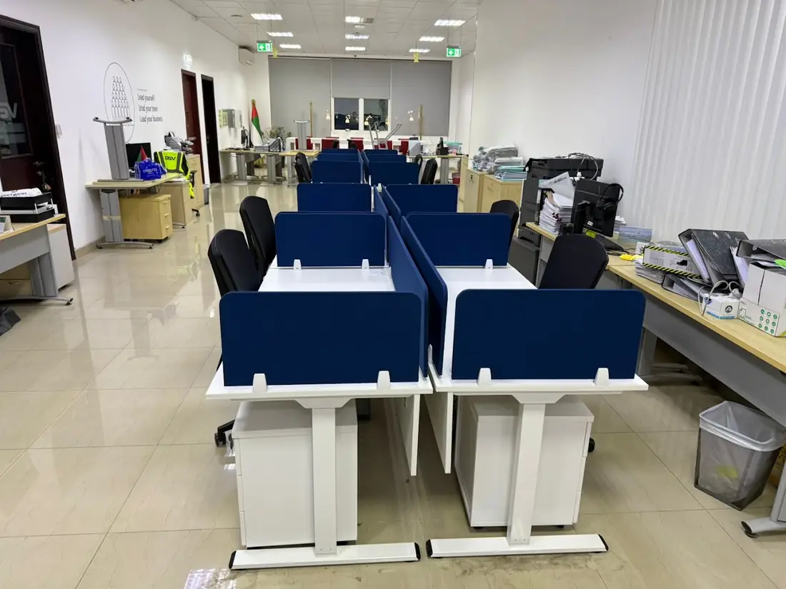 Rows of workstations with navy fabric screens in an open office