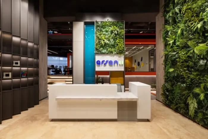 White reception counter beside a green living wall