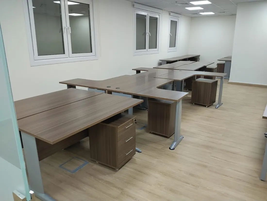 Walnut-top desks with mobile pedestals in a bright room